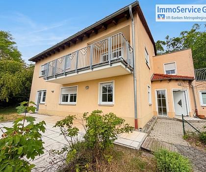 Einfamilienhaus am Hang mit Panorama und angrenzenden Waldgrundstücken.